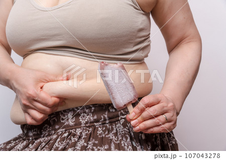 【お腹の肉を摘む主婦とでべそ アイス】 【お腹の肉を摘む主婦とでべそ アイス】 107043278