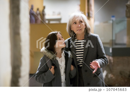 Senior woman and tween girl observing arts and crafts in museum Senior woman and tween girl observing arts and crafts in museum 107045683