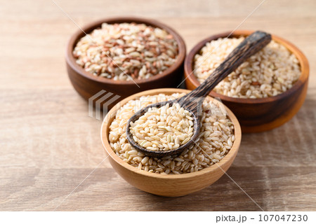 Thai brown rice seed in wooden bowl with spoon, Organic rice, Healthy food ingredient 107047230