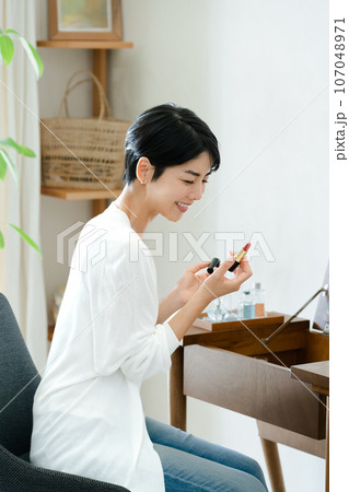 部屋でメイクをする女性 部屋でメイクをする女性 107048971