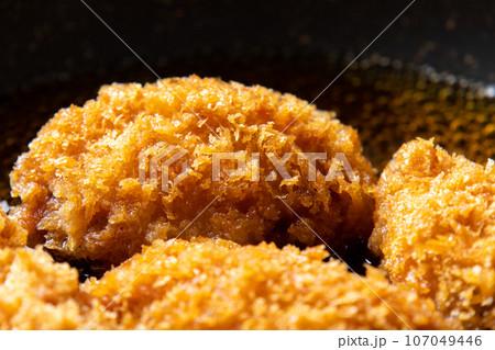 残った揚げ物(カキフライ)リメイク調理シーン。卵とじするためだし汁の入ったフライパンで煮る。 107049446