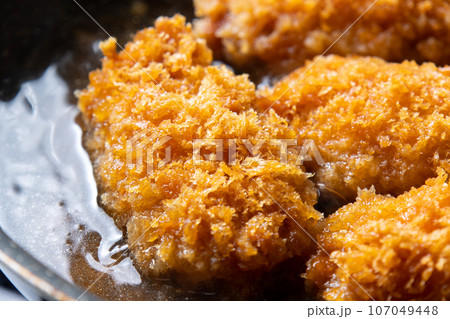 残った揚げ物(カキフライ)リメイク調理シーン。卵とじするためだし汁の入ったフライパンで煮る。 107049448