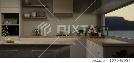 Copy space on a kitchen island in a modern Scandinavia kitchen with sink against the window. Copy space on a kitchen island in a modern Scandinavia kitchen with sink against the window. 107049954