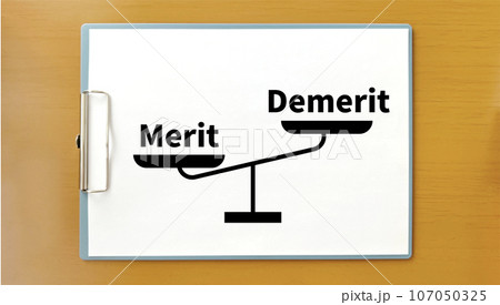 クリップボードに左下がりの秤イラストとMeritとDemerit文字_茶色の机の上 クリップボードに左下がりの秤イラストとMeritとDemerit文字_茶色の机の上 107050325