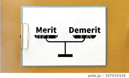 クリップボードに秤イラストとMeritとDemerit文字_茶色の机の上 クリップボードに秤イラストとMeritとDemerit文字_茶色の机の上 107050326