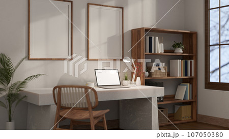 Minimalist white home office workplace with a laptop mockup on a white table against the white wall. 107050380