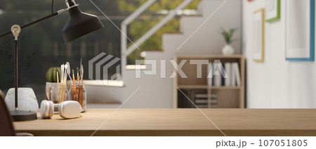 A wooden table with copy space with a blurred modern, minimal room with stairs in the background. A wooden table with copy space with a blurred modern, minimal room with stairs in the background. 107051805