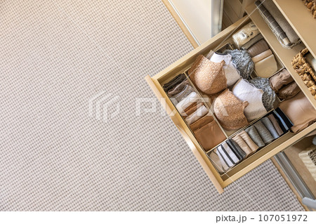 Drawer in the wardrobe with women's underwear, bras, briefs, socks and t-shirts. The concept of storage and order. 107051972