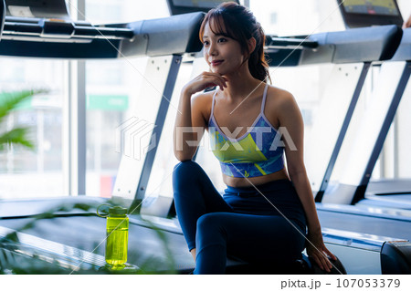 スポーツジムでトレーニングする若い女性 107053379