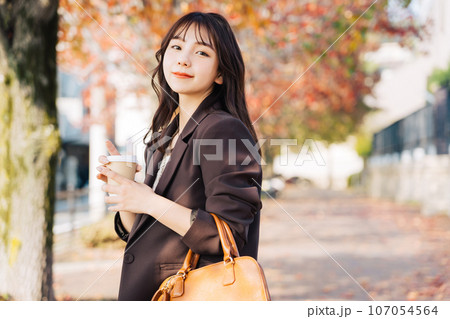 紅葉を背景ににコーヒーを飲む女性 紅葉を背景ににコーヒーを飲む女性 107054564