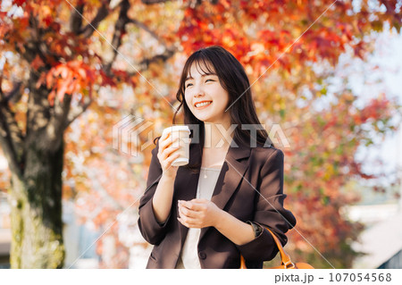 紅葉を背景ににコーヒーを飲む女性 紅葉を背景ににコーヒーを飲む女性 107054568