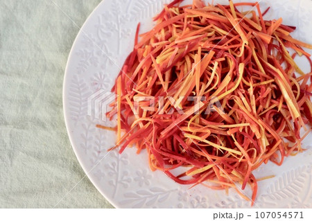 白い皿に盛られたカラフルな人参のきんぴら・2 107054571