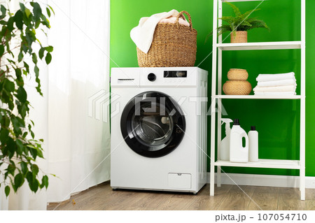 Modern white washing machine in a laundry room 107054710