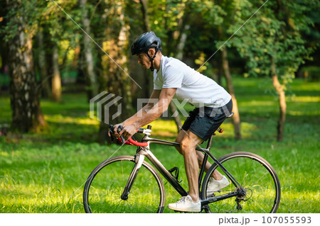 Young male cyclist riding a bike in the forest 107055593
