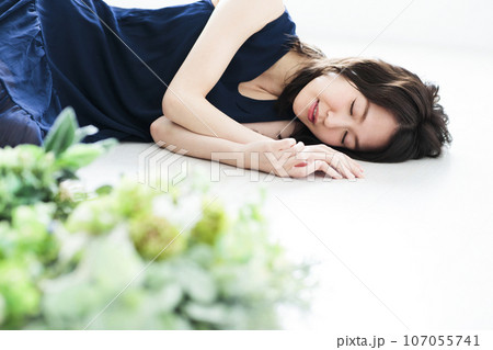 花束の横で寝転ぶ若い女性 107055741