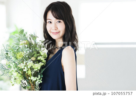 リビングでフラワーアレンジメントをする若い女性 107055757