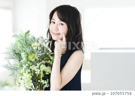 リビングでフラワーアレンジメントをする若い女性 107055758