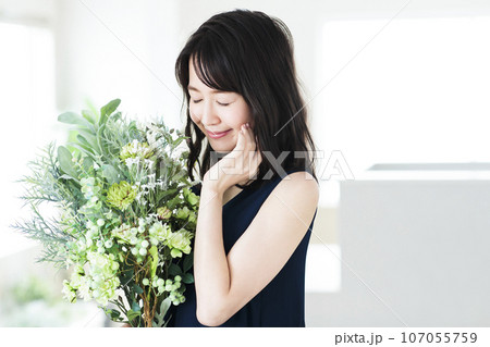 リビングでフラワーアレンジメントをする若い女性 リビングでフラワーアレンジメントをする若い女性 107055759