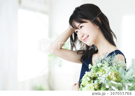 リビングでフラワーアレンジメントをする若い女性 リビングでフラワーアレンジメントをする若い女性 107055768