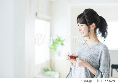 リビングで紅茶を飲む若い女性 107055829