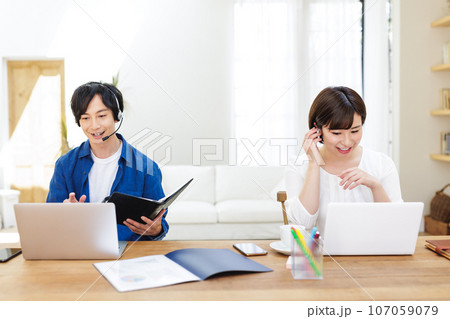 自宅でテレワークをするカップル 自宅でテレワークをするカップル 107059079