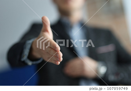 Man in suit stretches out here for handshake Man in suit stretches out here for handshake 107059749