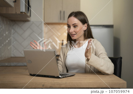 Young employee working online with a laptop from home is excited about achieving good sales. A young student is surprised to receive an email from college with excellent exam results 107059974