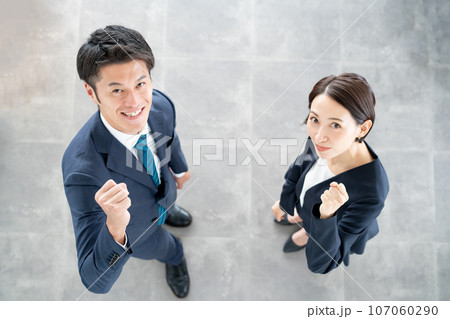 笑顔でガッツポーズをする男女 107060290