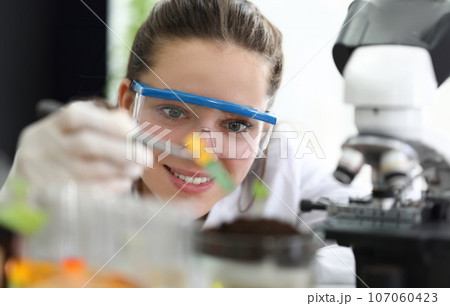 Female researcher with glasses conducts soil research 107060423