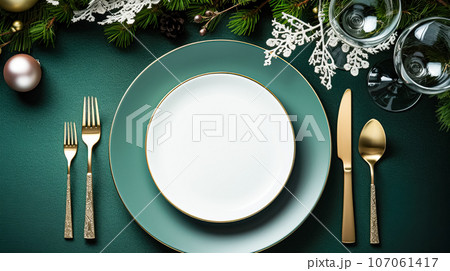 Modern holiday table setting, white empty plates, glass glitter ball decorations, green table, winter holidays, mockup 107061417