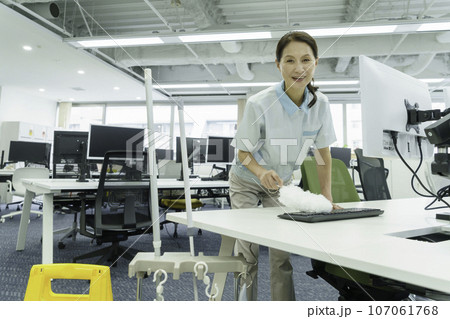 オフィスでキーボードの埃を取る女性清掃員 107061768