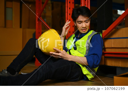 Asian male worker having accident in warehouse during work injured head Safety first and Injury at work 107062199
