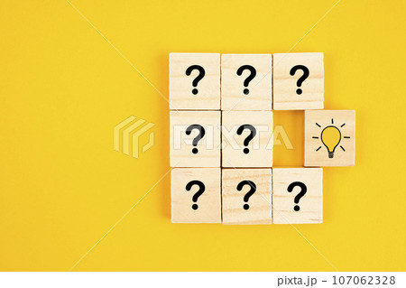 The wooden cube with hand drawn light bulb next to the cubes with question marks. Concept of problem solving, creativity, idea or innovation. 107062328