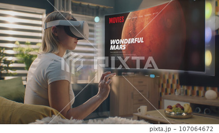 Woman in VR headset chooses movie or TV show. VFX animation 107064672