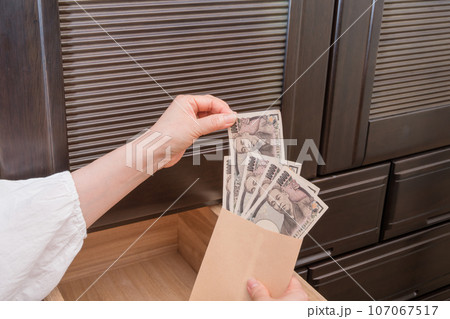 【主婦がたんすの引き出しに封筒入りの一万円札を隠す】 107067517