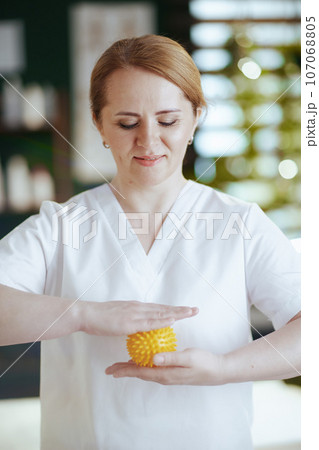massage therapist woman in spa salon with massage ball 107068805