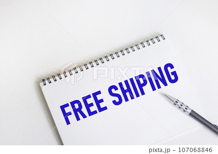 Notepad with the text FREE SHIPPING on a white background with a pen Notepad with the text FREE SHIPPING on a white background with a pen 107068846