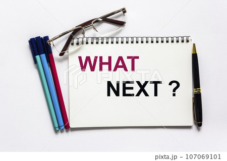 Text written on notepad What's Next, concept on a white background. Nearby are markers 107069101