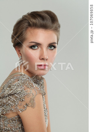 Beautiful woman face closeup portrait. Perfect model with makeup and jewelry earring  107069858