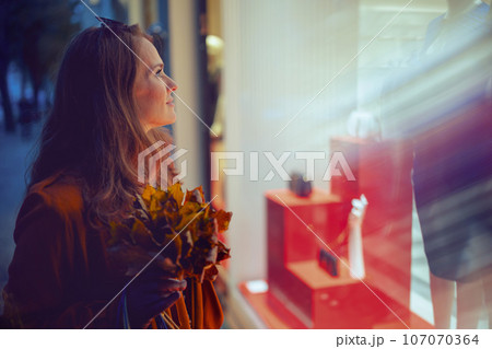 elegant woman in orange trench coat elegant woman in orange trench coat 107070364