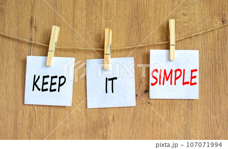 Keep it simple symbol. Concept word Keep it simple on beautiful white paper on wooden clothespin. Beautiful wooden table wooden background. Business motivational keep it simple concept. Copy space. 107071994