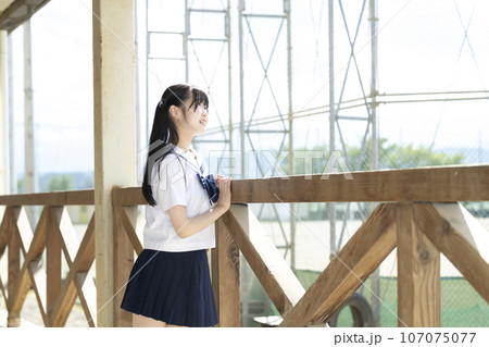 学校の校舎と女子生徒 107075077