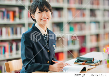図書室で資料を広げて微笑む女子高生 図書室で資料を広げて微笑む女子高生 107075309