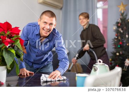 Father and son cleaning room together before christmas Father and son cleaning room together before christmas 107076638