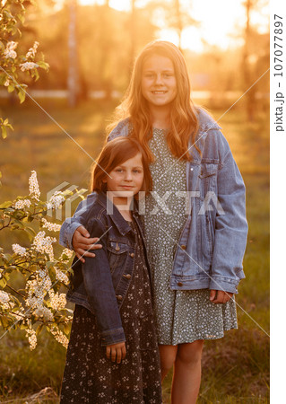 Older and younger sister in the field portrait 107077897