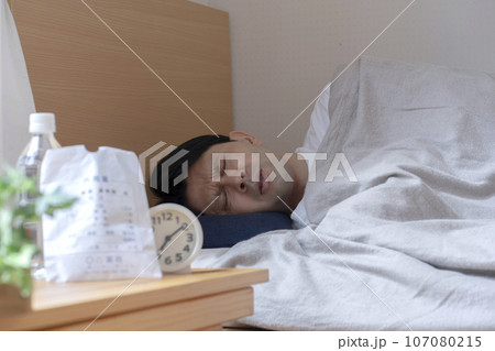 体調不良で寝込む男性 107080215