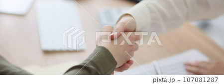 Close-up of handshake over office desk. 107081287