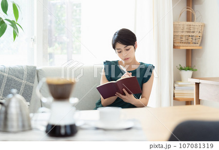 リビングで手帳を見る女性 リビングで手帳を見る女性 107081319