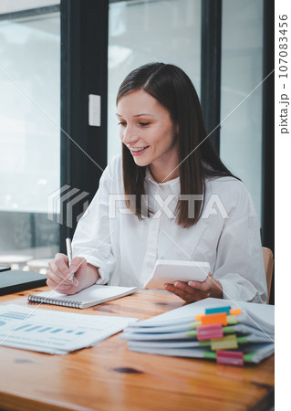 Business woman using business paper for doing math finance on office desk, tax, report, accounting, statistics, and analytical research concept Business woman using business paper for doing math finance on office desk, tax, report, accounting, statistics, and analytical research concept 107083456