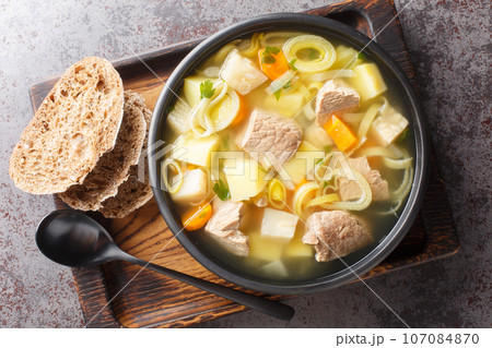 Kottsoppa soup is a meat and root vegetables include carrot, potato, celeriac, parsnip, turnip and Rutabaga close-up on a plate. Horizontal top view Kottsoppa soup is a meat and root vegetables include carrot, potato, celeriac, parsnip, turnip and Rutabaga close-up on a plate. Horizontal top view 107084870
